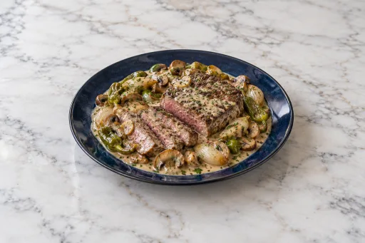 Bistec de avestruz con pimiento y champiñones